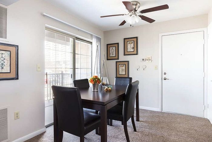 Bright dining area with sleek black chairs, a modern table, and elegant artwork, perfect for cozy gatherings.