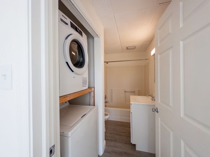 Bright and functional apartment corner featuring an in-unit washer and dryer next to a modern bathroom with sleek fixtures.