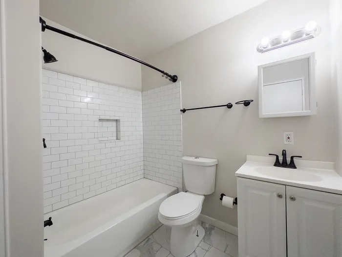 Modern bathroom with sleek white subway tiles, elegant vanity, and bright lighting for a fresh, inviting atmosphere.
