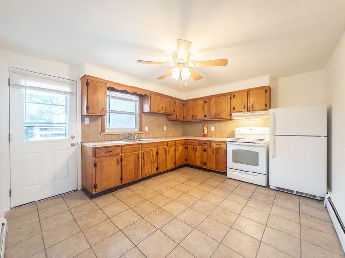 Charming kitchen with vintage wooden cabinets, modern appliances, and abundant natural light.