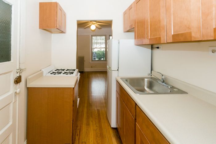 A functional kitchen space with gas range and stainless steel sink.
