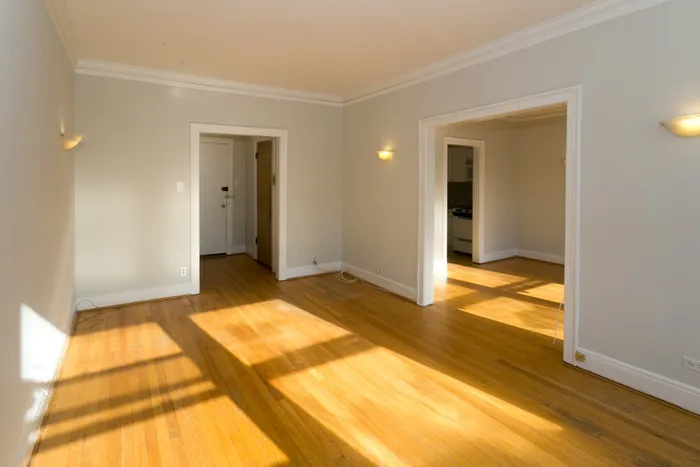 A living room with hardwood floors and light grey walls.