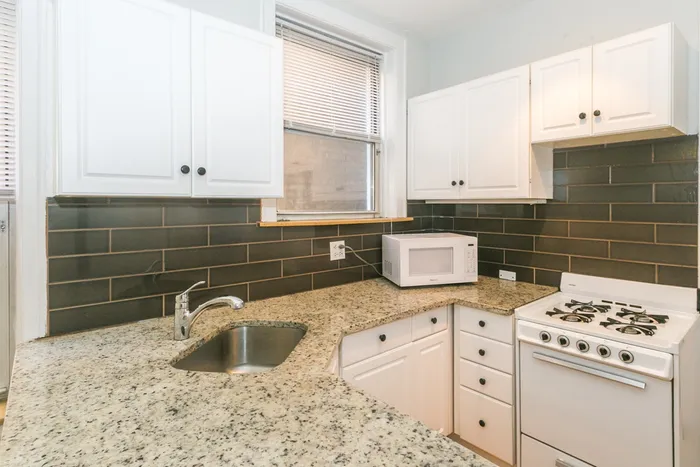 An upgraded kitchen with dishwasher, and white appliances.