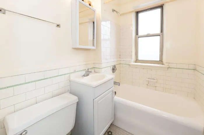 A bathroom with a white vanity, bathtub, and vintage charm.