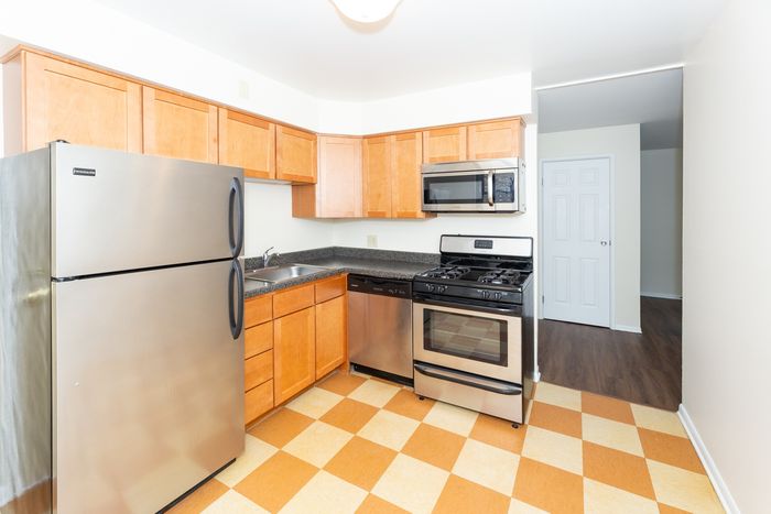 Kitchen with stainless steel appliances including a microwave.