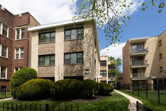1644 West Sherwin a twelve unit mid century property with a yellow brick exterior and a landscaped front yard in Rogers Park.