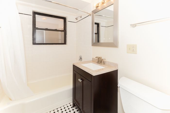 Bathroom with dark wood vanity and a bathtub.