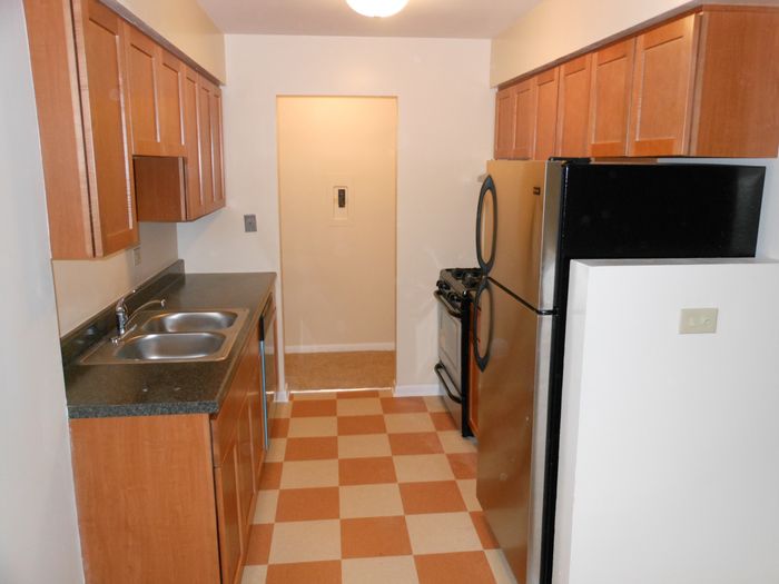 Kitchen with wooden cabinets, and stainless steel appliances including a dishwasher.