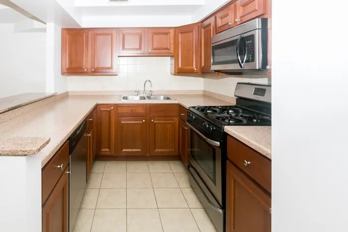 Kitchen with stainless steel appliances including a microwave, dishwasher, and breakfast bar.