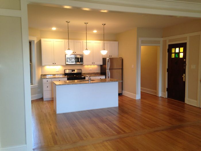 An upgraded open concept kitchen with a dishwasher, stainless steel appliances and pendant lighting.