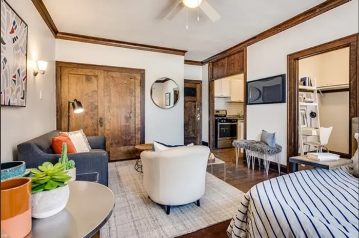 A model living room with hardwood floors, crown molding, and a neutral color palette.