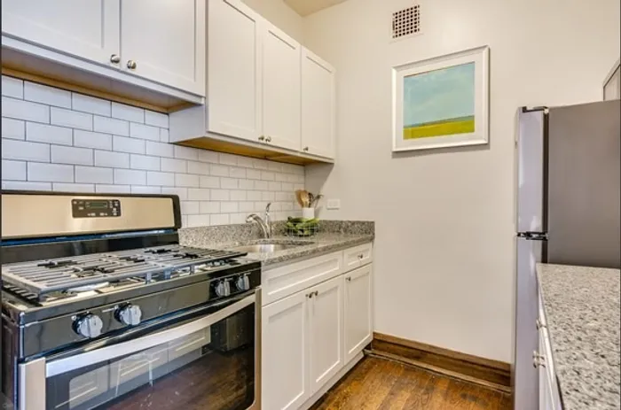 Separate kitchen with granite tops and stainless steel appliances.