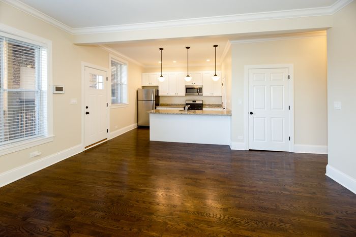 A kitchen / dining / work from home space with hardwood floors and a neutral color palette.