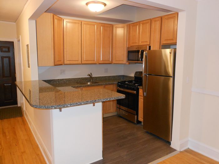 Kitchen with stainless steel appliances including a microwave.