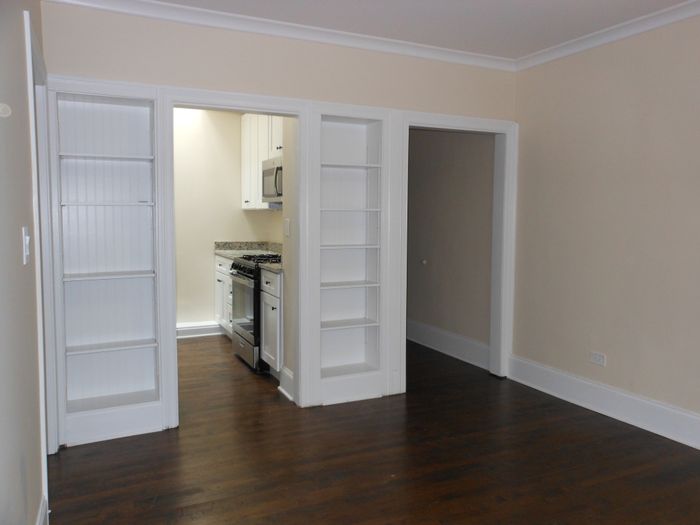 Living room with built in shelving and a neutral color palette.