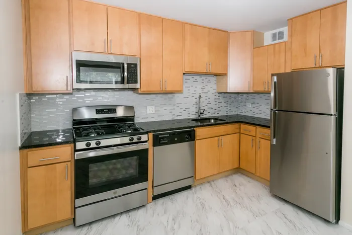Kitchen with stainless steel appliances including a microwave.