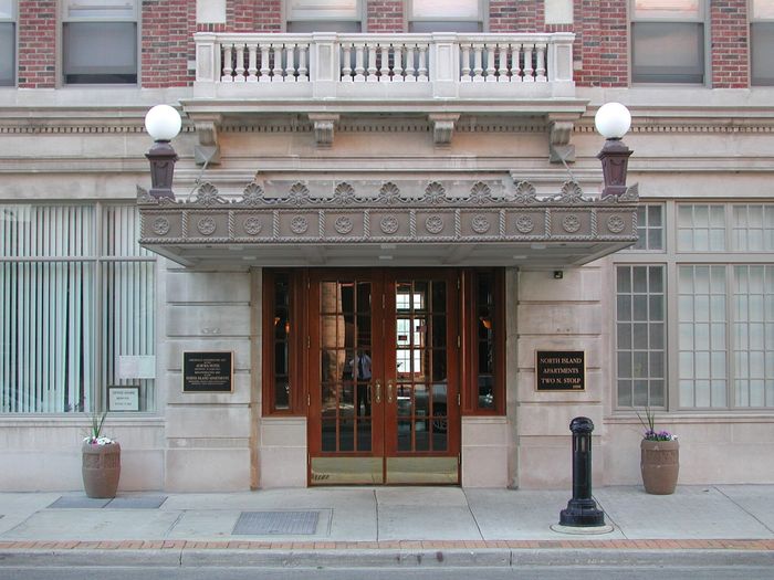North Island Apartments an historic main entrance in limestone and wood to a fifty seven unit senior building in Aurora Illinois.