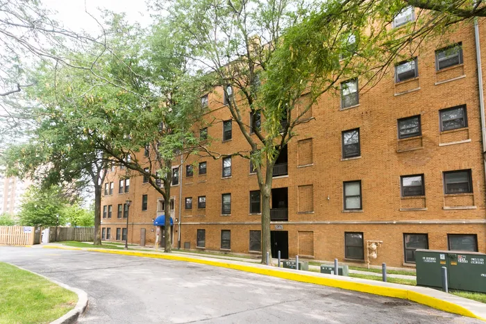 Exterior of Lakeside Manor a handsome one hundred and three unit 3.5 story yellow brick courtyard building with a private beach in South Shore.
