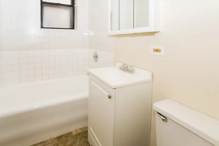 Bathroom with a white vanity and bathtub.