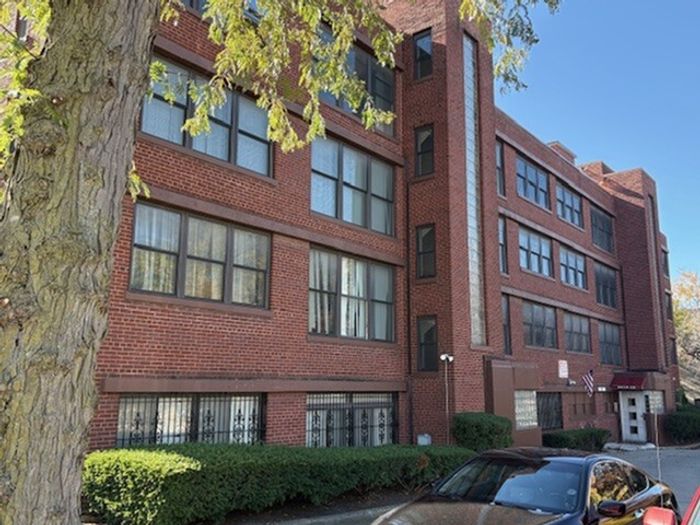 Red brick 4 story apartment building with dark windows