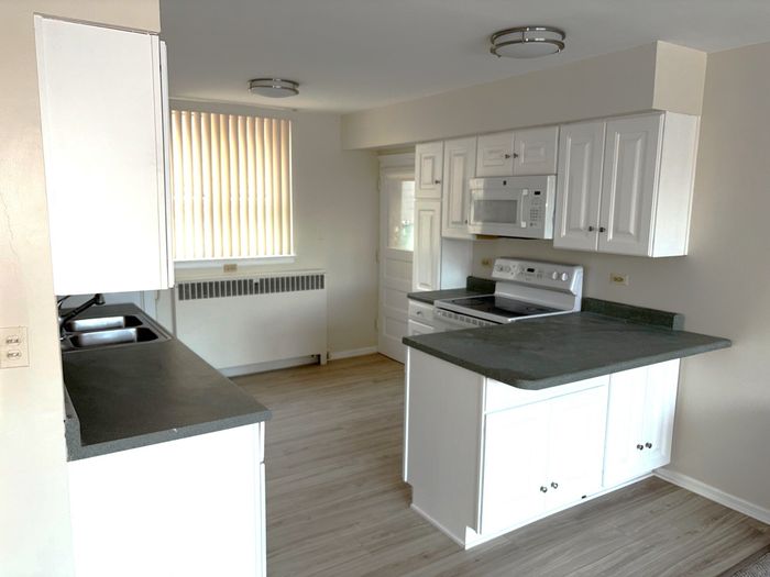 Kitchen with white cabinets and dark counter tops