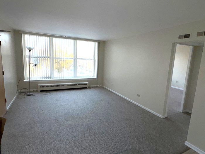 Large carpeted living room connected to the kitchen