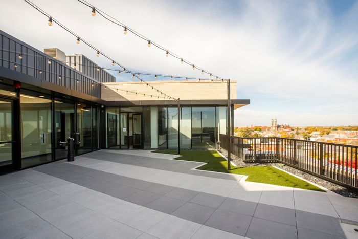 Roof deck with gray decking looking at the party room windos