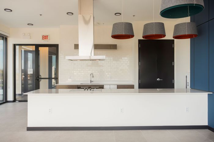 Large common kitchen area with blue accent wall and cooking hood