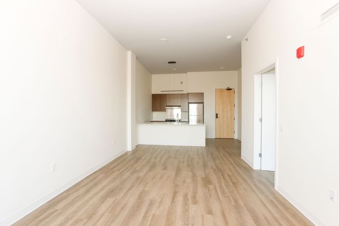 Open concept living area and kitchen with woodgrain cabinets