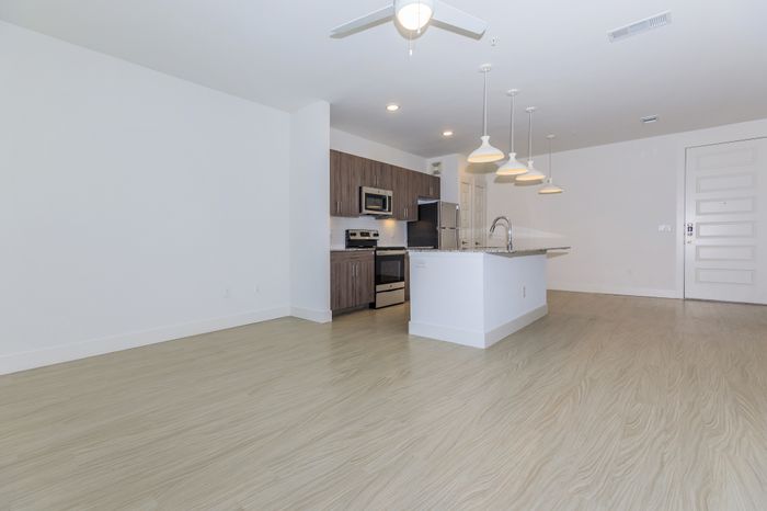 A spacious living area next to a clean and modern kitchen