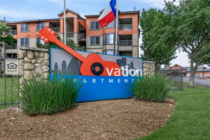 Signature guitar monument sign at Ovation Apartments in Austin, TX, highlighting the community’s connection to Austin’s musical roots.
