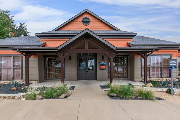 Clubhouse with modern architecture and well-maintained landscape at Ovation Apartments in Austin, TX, offering luxury community spaces