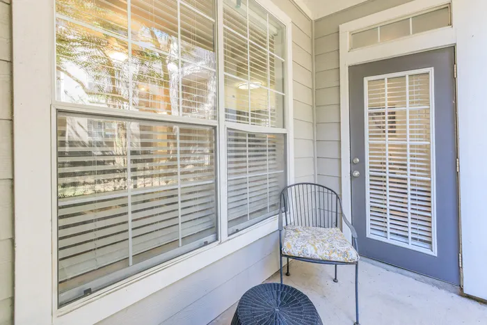 a patio with an outdoor chair and wicker decor
