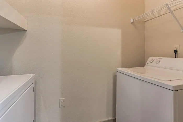 Modern washer and dryer units in a spacious laundry area at Riverside at Rockwater, North Little Rock, AR