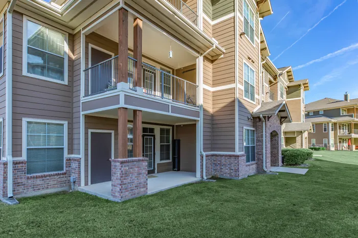 View of the back of the apartment building with landscaped grounds at Riverside at Rockwater, North Little Rock, AR