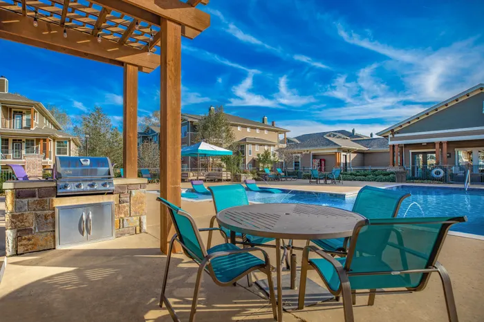 Outdoor grilling area with seating and scenic views at Riverside at Rockwater, North Little Rock, AR