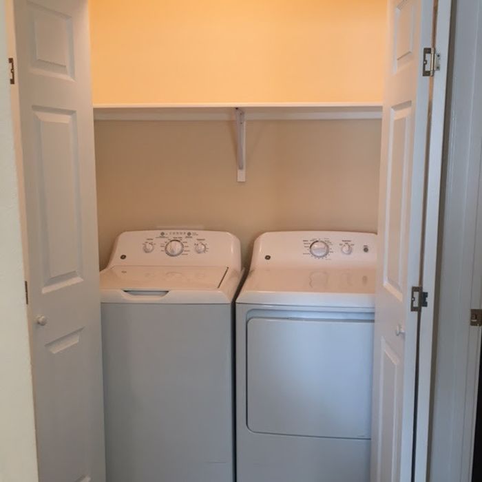 Front-loading washer and dryer set in a modern laundry room at Bella Vista Place, El Paso, TX