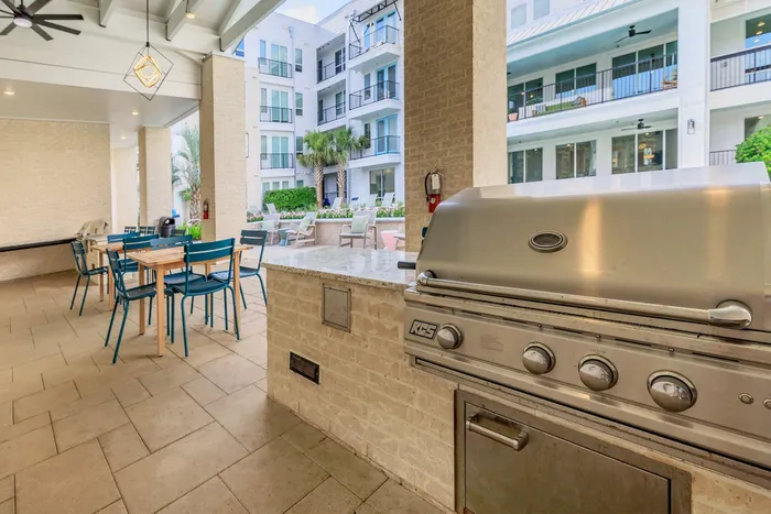 outdoor grilling area with chairs, tables, and tile flooring