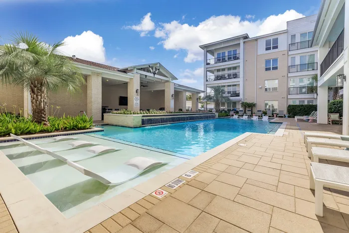 swimming pool with chairs, clean water, and wide walkways