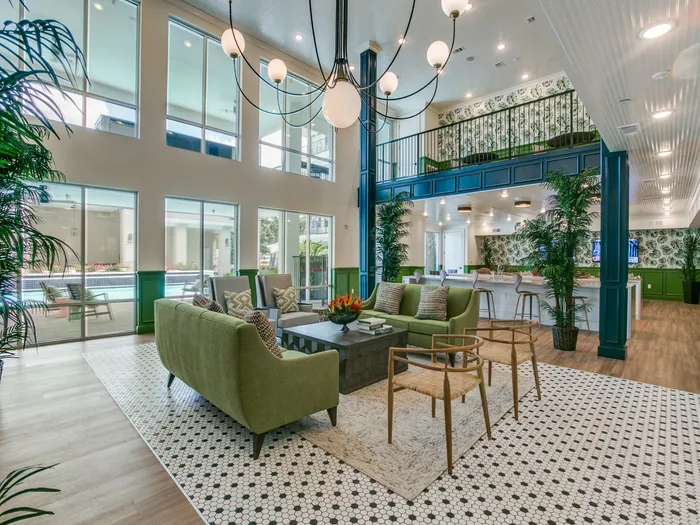 cozy community clubhouse with multiple floors visible from a central seating location filled with comfortable couches, chairs, and a nice view of the swimming pool through the window