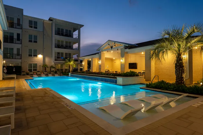 swimming pool at night surrounded by lighting and clean walkways