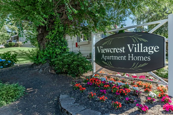 Prominent monument sign at the entrance of Viewcrest Village Apartments, showcasing the community name and logo.