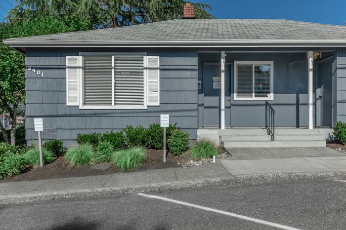 Exterior of the leasing office at Viewcrest Village Apartments in Bremerton, WA, surrounded by landscaped greenery.