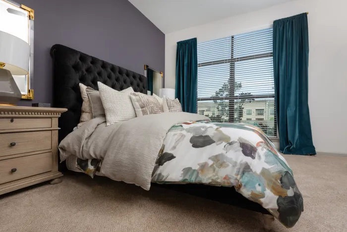 Luxurious bedroom with a plush bed and large windows at The Hendry Apartments in Garland, TX.