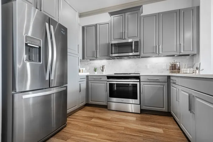 Beautifully designed gray kitchen cabinets and state-of-the-art appliances in The Hendry Apartments, Garland, TX.