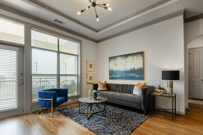 Elegant living room with modern decor and large windows at The Hendry Apartments, Garland, TX.