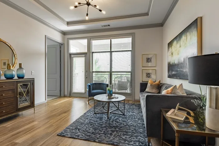 Elegant living room with modern decor and large windows at The Hendry Apartments, Garland, TX.