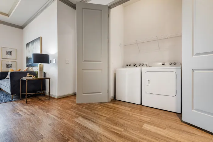 Spacious laundry area with modern washer and dryer in The Hendry Apartments in Garland, TX.