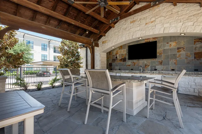 Cozy outdoor lounge with wooden beams and plush seating at The Hendry Apartments in Garland, TX.