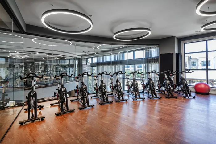 Spacious cycling and yoga studio with mirrors and natural light at The Hendry Apartments, Garland, TX.